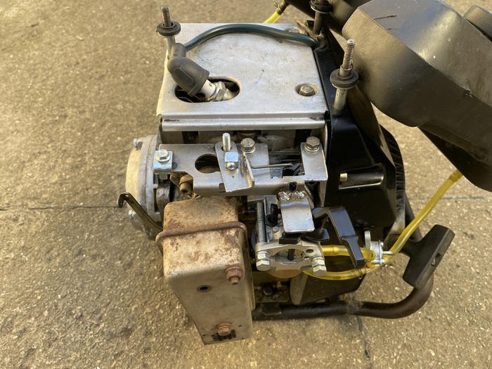 Прикручен. По центру на шпильке можно видеть подвижный элемент акселератора, слева прижим оплетки троса