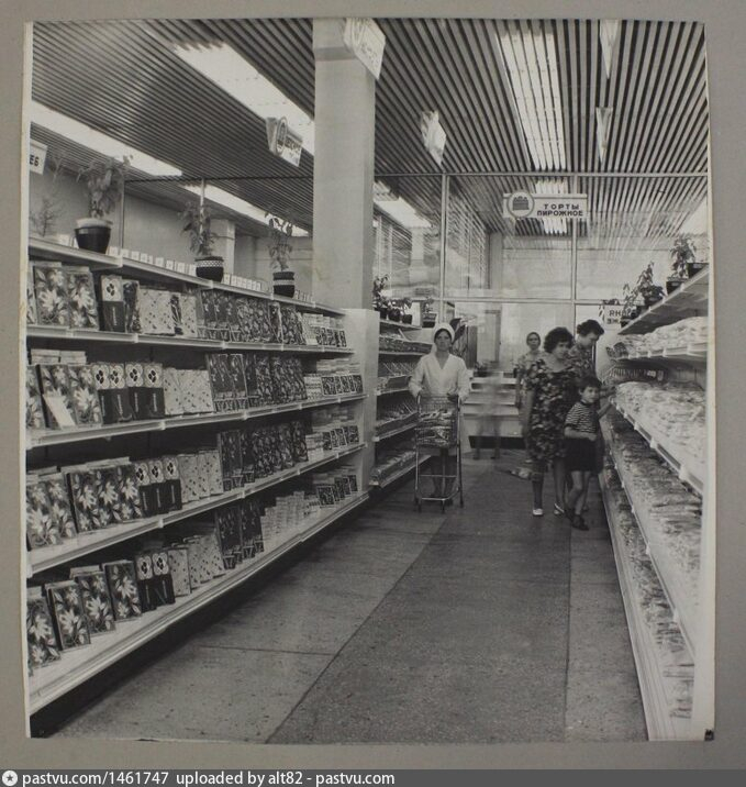 Автозаводский универсам, кондитерский отдел, сзади продавщицы с тележкой, за стекляной стеной, мясной отдел и производственный (холодильники, разделка, упаковка, разрезка и взвешивание)