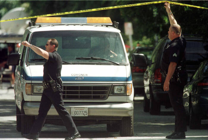 Фургон коронера вывозит тела Фила Хартмана и его жены из их дома в Энсино, Калифорния, 28 мая 1998 года.