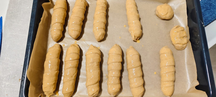 Ленту накручиваю на сосиску. Укладываю на противень Смазываю взбитым яйцом. Ещё тесто осталось. Просто булочки будут. С младшим готовим. Учу его с тестом работать. Он сам булочки эти слепил.