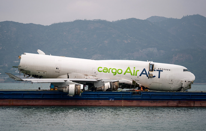 Фюзеляж выкатившегося в море самолета погрузили на баржу для эвакуации в Гонконге//Фото: Zuma/ТАСС