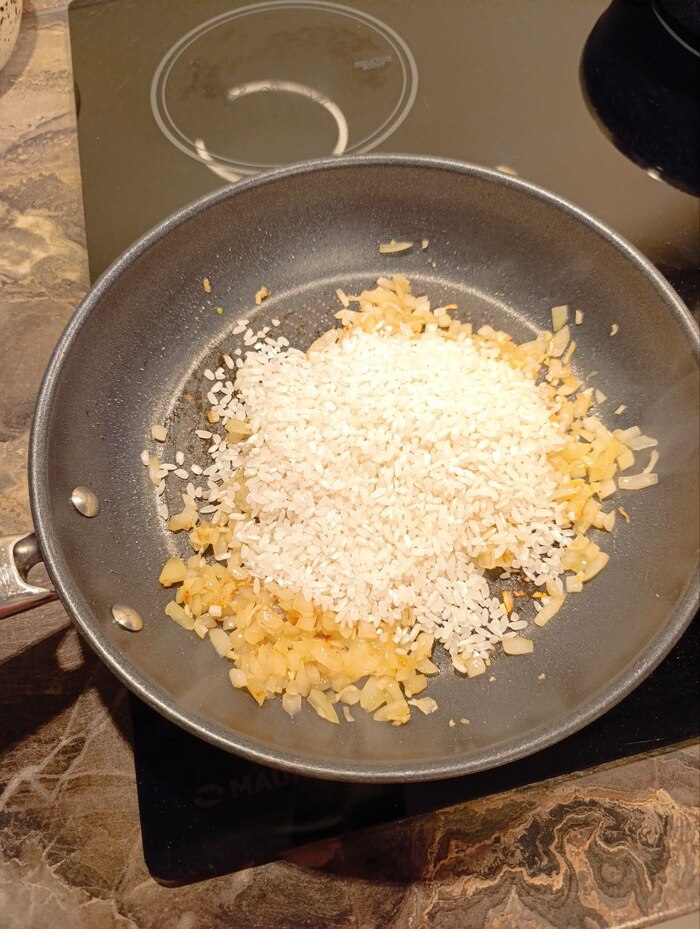 Обжариваем лук и чеснок минуты 2 , добавляем рис и продолжаем обжаривать