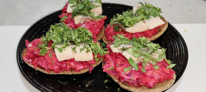 Выкладываю на подсушенный хлеб овощную смесь. Сверху сельдь и зелень