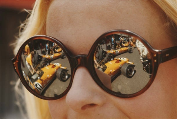 Болид McLaren M14A Ford отражается в женских солнцезащитных очках в боксах во время Гран-при Франции на трассе «Шарад» 4 июля 1970 года