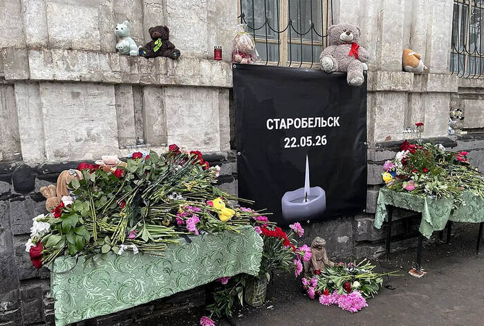 Стихийный мемориал у разрушенного здания общежития Старобельского колледжа. Жители города несут цветы, игрушки и свечи в память о погибших студентах. 2026
